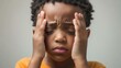 © Mykola - Touching Temples: African American Boy Experiencing Headache, Discomfort, and Anxiety