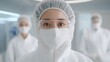 © Pedro - A Japanese scientist wearing a full cleanroom suit, including a face mask, gloves, and protective eyewear, holds a small high-tech device