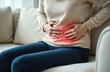 © Vadym - Woman experiences abdominal pain, holds belly with hands, discomfort during menstruation. Upset girl suffers from period cramps. Red color indicates pain location. Concept of female health, illness,
