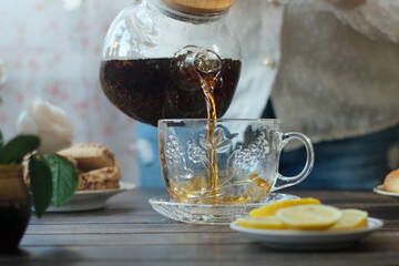 Sticker - Tea gathering. Woman pouring brewed black tea into cup.