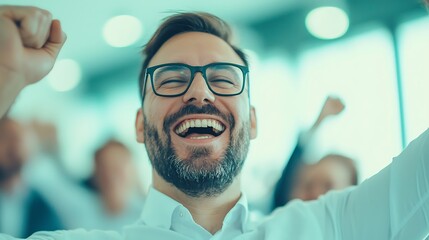 Wall Mural - A joyful man with glasses celebrates enthusiastically in a bright environment, showcasing happiness and engagement.