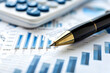 © rizkan - Close-up of a pen and calculator on financial graphs showcasing data analysis in an office setting