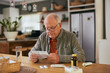 © Rido - Old man wearing specs and reading medicine leaflet