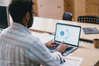 © BullRun - Unrecognizable man working on laptop while sitting at table in office