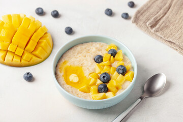 Wall Mural - Oatmeal porridge with mango and blueberries. Healthy breakfast