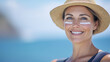© LotusBlanc - Mid Age Woman Wearing Straw Hat, Sunscreen on Face, Sun UV Protection, Healthy Sunbathing, and Skin Cancer Prevention, Sea Background.