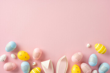 Wall Mural - decorative pastel easter eggs and bunny ears arranged on a pink surface in a festive layout