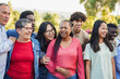 © Sabrina - Crowd of multiracial people having fun together in front of camera outdoor - Multi generational group and community concept - Focus on african woman face