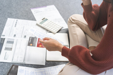 Wall Mural - Business financial concept, stressed asian young woman hand checking list with bill for calculate accounting expense credit card payment on due deadline, trying to find money to pay debt on table.