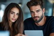 © jureephorn - Focused male and female architects reviewing project specifications on a digital tablet, large-scale construction site in the background, clear and professional environment