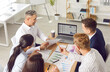 © Studio Romantic - Business team doing data analysis during work meeting. Group of people sitting together at office table, discussing professional marketing tools, using laptop computer, and drinking coffee