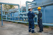 © reewungjunerr - Petrochemical engineer working at petroleum oil refinery industry area. Industrial technician worker maintenance inspect manufacturing energy power gas system at factory.