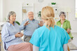 © Studio Romantic - Talking activities for seniors in retirement living, residents speaking with nurse, doctor caregiver wearing uniform, hobby speaking club to encourage retired older patients, group psychotherapy