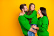 © deagreez - Photo of cheerful charming cute family with mommy and daddy embracing their daughter holding with hands wearing red jeans denim smiling toothily isolated vivid yellow color background