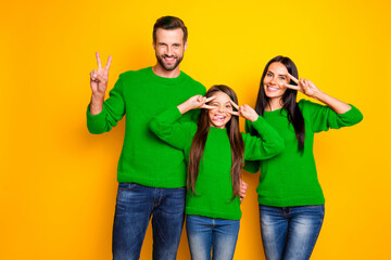 Photo of cute nice happy family day with daughter fooling sticking out showing v-sign tongue grimacing crazily wearing red sweater jeans denim isolated vivid color yellow background