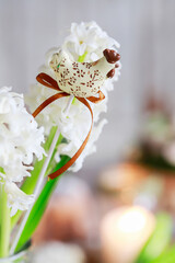 Wall Mural - A figure of a hen on a stick among a bouquet of white hyacinths. Easter symbol, postcard motif.