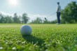 © Atmospheric stock - Close-up of golf ball on green with male golfer in background under sunny sky