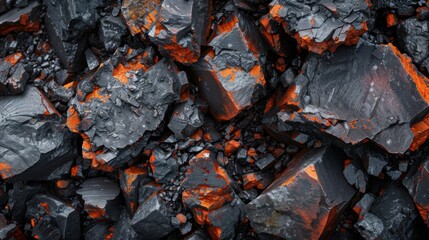 Leinwandbilder - The collection of dark mineral rocks interspersed with vibrant orange highlights reflects unique geological processes at work in an outdoor environment.