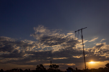 Wall Mural - sunset sky with clouds and electricity pole in the countryside of thailand