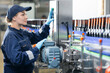 © Parilov - Female worker working on beer factory production line operating machinery, food industry