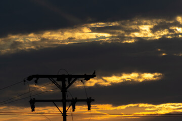 Wall Mural - silhouette of high voltage post at sunset with dramatic sky.