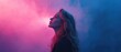© Fernando - Caucasian woman with long blonde hair looking up in profile view against a vibrant pink and blue smoky background Concept of mystery, dream, hope, and contemplation