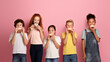 © Prostock-studio - Cute diverse children eating yummy donuts against pink background