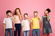 © Prostock-studio - Diverse schoolkids holding yummy donuts in front of their faces on pink background