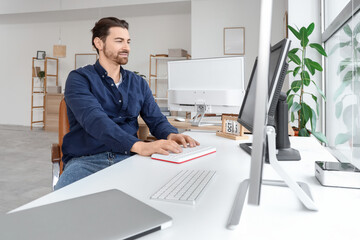 Wall Mural - male programmer at workplace in office