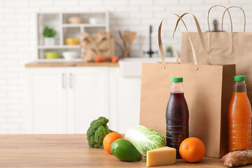 Wall Mural - Paper bags with different fresh products on wooden table in kitchen