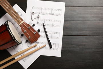 Wall Mural - Composition with music sheets, musical instruments and earphones on dark wooden background