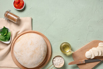 Wall Mural - Wooden board with raw dough and ingredients for pizza on light grunge background