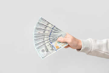 Wall Mural - Man holding dollar banknotes on light background