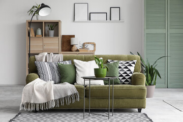 Wall Mural - Interior of living room with green sofa and Sansevieria plants