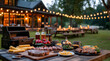 © Olha Havelia - A rustic wooden table set up for an outdoor barbecue, with various grill-themed decorations and the food on it, in front of a large backyard setting at night. The scene includes mu