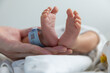 © Rattanachat - new born baby feet hold mother's hand with blurred QR Code of identity tag. concept : Premature or preterm baby in hospital. relationship between mother and baby.