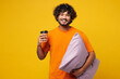 © ViDi Studio - Calm young Indian man he wearing orange pyjamas jam sleep rest relax at home hold purple pillow, cup drink coffee tea isolated on plain yellow background studio portrait. Good mood night nap concept.