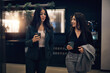 © Flamingo Images - Smiling businesswomen walking with coffees through a hotel lobby. They talk and smile about a successful meeting