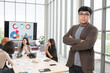 © PhugunStock - Asian male businessman standing with arms crossed looking at camera, businessman brainstorming, discussing analysis, innovation, collaboration online business Sales techniques and strategic planning