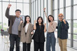 © PhugunStock - Asian business men and women look at the camera, raising their hands in joy. After brainstorming, talk about analytics, innovation, collaboration. Online business, sales techniques, strategic planning
