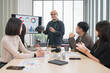 © PhugunStock - Asian male businessman standing explaining meeting, smiling happily and brainstorming, discussing analysis, innovation, collaboration. online business Modern sales techniques and strategic planning