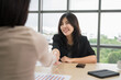 © PhugunStock - Asian businesswomen happily cheer and shake hands with fellow attendees, brainstorming and discussing analysis, innovation, collaboration. online business Modern sales techniques strategic planning
