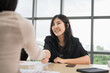 © PhugunStock - Asian businesswomen happily cheer and shake hands with fellow attendees, brainstorming and discussing analysis, innovation, collaboration. online business Modern sales techniques strategic planning