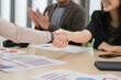 © PhugunStock - Asian businesswomen happily cheer and shake hands with fellow attendees, brainstorming and discussing analysis, innovation, collaboration. online business Modern sales techniques strategic planning