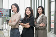 © PhugunStock - Asian businesswoman stands happily looking at the camera, arms crossed. After talking about analytics, innovation and collaboration. Online business, sales techniques, strategic planning