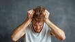 © senadesign - Man expresses intense frustration with disheveled hair and pained expression during a challenging moment indoors