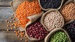 © Suphawan - A selection of different dry legumes, including kidney beans, black-eyed peas, and lentils, on a wooden table, promoting clean eating