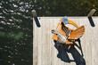 © Tetra Images - Overhead view of adirondack chair with book and blanket on pier on Lake Placid