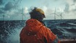 © Антон Сальников - At an offshore farm, a wind turbine technician wearing full safety gear gazes out at the distant high seas