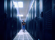 © Tetra Images - Female technician walking in server room